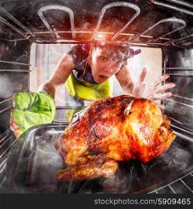Funny Housewife overlooked roast chicken in the oven, so she had scorched (focus on chicken), view from the inside of the oven. Housewife perplexed and angry. Loser is destiny! Thanksgiving Day.