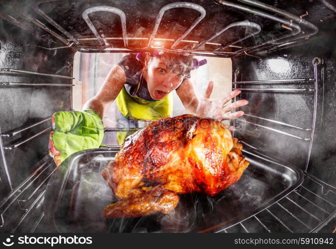 Funny Housewife overlooked roast chicken in the oven, so she had scorched (focus on chicken), view from the inside of the oven. Housewife perplexed and angry. Loser is destiny! Thanksgiving Day.