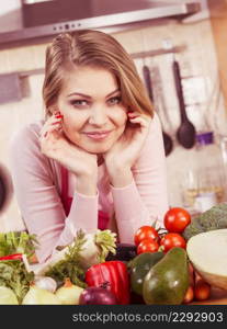 Funny joyful young woman, cooking chef having many healthy vegetables on table. Tomatoes, onion, lettuce, pepper. Vegetarian lifestyle concept.. Woman having vegetables on table