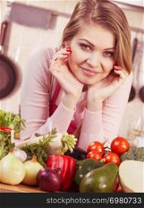 Funny joyful young woman, cooking chef having many healthy vegetables on table. Tomatoes, onion, lettuce, pepper. Vegetarian lifestyle concept.. Woman having vegetables on table