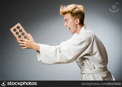 Funny karate fighter with clay brick