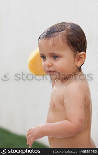 Funny kid showering in the yard for a summer afternoon