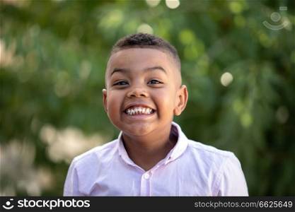 Funny latin child in a park, laughing with a funny expression