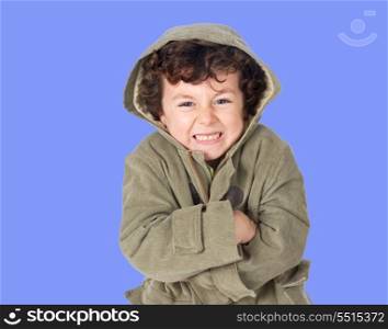 Funny little boy shivering with cold on a blue background