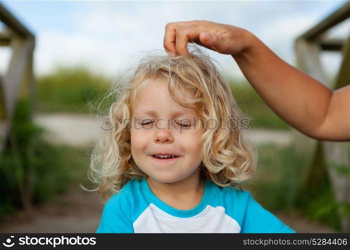 Funny little child with closed eyes while his mother comb him