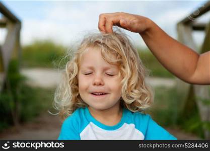 Funny little child with closed eyes while his mother comb him