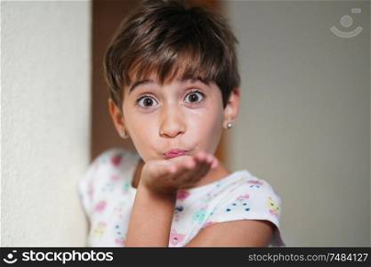 Funny little girl, eight years old, blowing a kiss to camera.. Funny little girl, eight years old, blowing a kiss