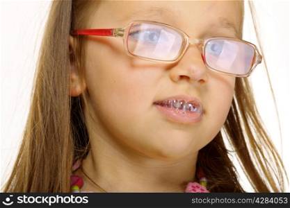 Funny little girl in glasses doing fun saliva bubbles studio shot isolated on white background
