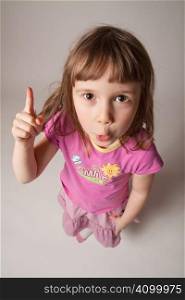 Funny little girl raising one finger