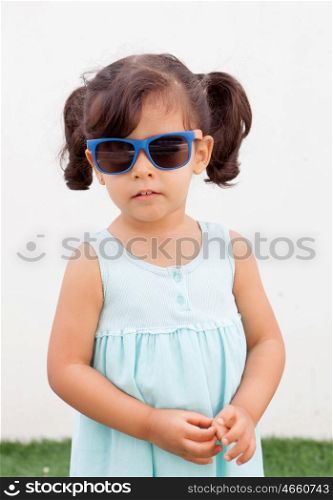 Funny little girl with pigtails and blue dress outdoor