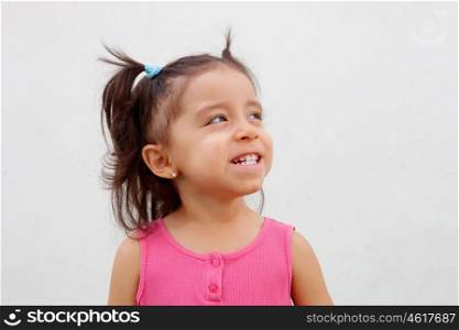 Funny little girl with pigtails and pink dress isolated on a white background