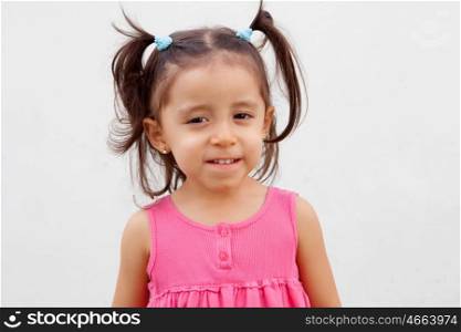Funny little girl with pigtails and pink dress isolated on a white background