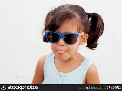 Funny little girl with pigtails and sunglasses outdoor