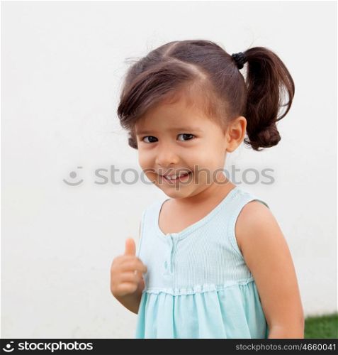 Funny little girl with pigtails saying Ok outdoor