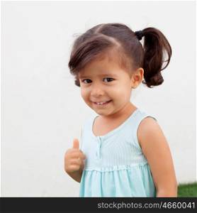 Funny little girl with pigtails saying Ok outdoor