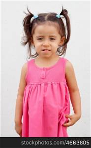 Funny little girl with pink dress looking at camera
