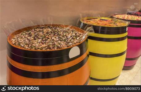 Funny looking sweets, chocolate candies in shapes and colors as stones, placed on wooden barrels.