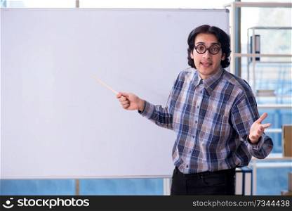 Funny male teacher in front of whiteboard 