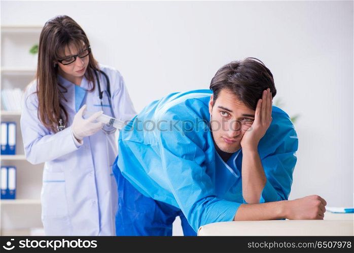 Funny man getting ready for buttocks syringe shot