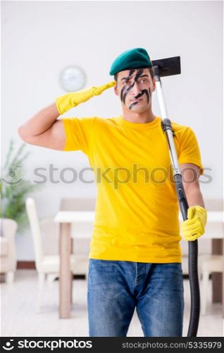 Funny man in military style cleaning the house