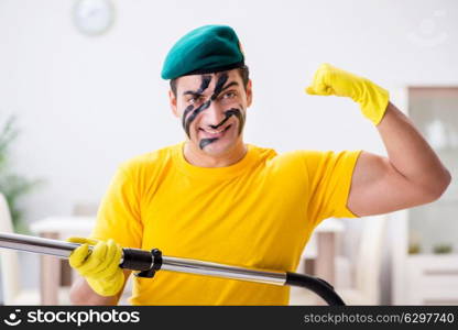 Funny man in military style cleaning the house