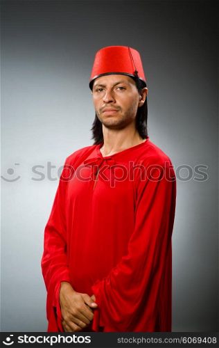 Funny man in red dress wearing fez hat