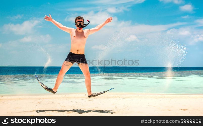 Funny man jumping in flippers and mask. Holiday vacation on a tropical beach at Maldives Islands.