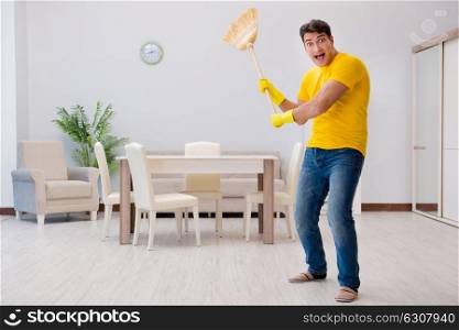 Funny man playing virtual guitar with broom