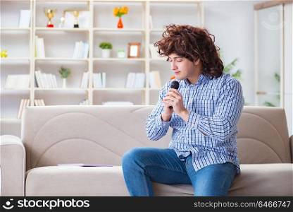 Funny man singing songs in karaoke at home