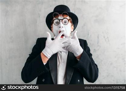 Funny mime actor with makeup mask. Pantomime in suit, gloves and hat. April fools day concept. Funny mime actor with makeup mask