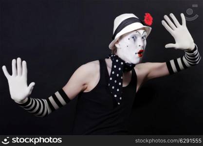 Funny mime in white hat with red flower on a black background