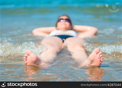 Funny photo of a beautiful girl lying in the sea