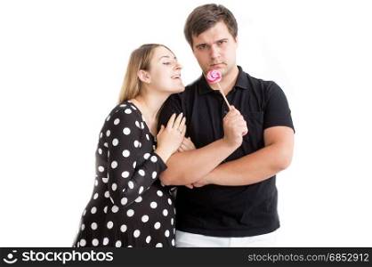 Funny portrait of young couple posing with lollipop