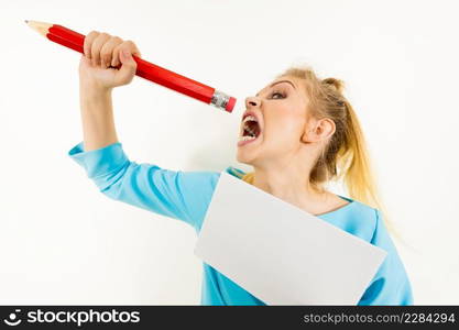 Funny≠rvous woman being stressed out about work or school. Teena≥fema≤holdingπece of paper and biting big oversized pencil. Funny woman biting big pencil