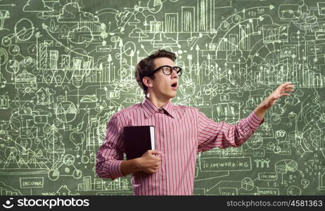 Funny scientist. Young funny man in glasses against chalk blackboard