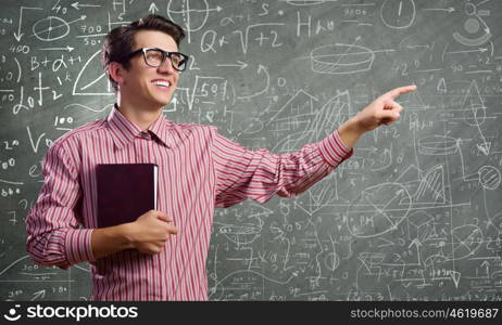 Funny scientist. Young funny man in glasses against chalk blackboard