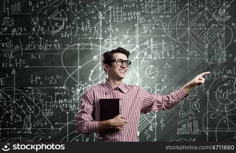 Funny scientist. Young funny man in glasses against chalk blackboard