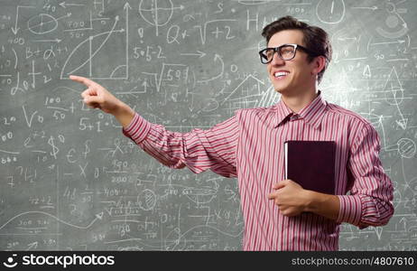 Funny scientist. Young funny man in glasses against chalk blackboard