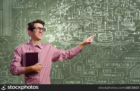 Funny scientist. Young funny man in glasses against chalk blackboard