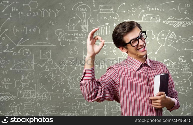 Funny scientist. Young funny man in glasses against chalk blackboard