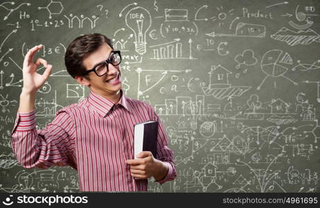 Funny scientist. Young funny man in glasses against chalk blackboard