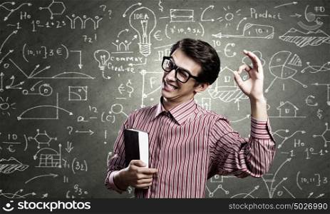 Funny scientist. Young funny man in glasses against chalk blackboard