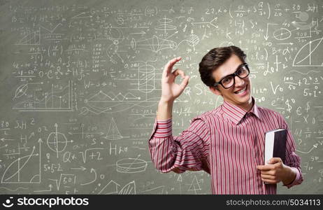 Funny scientist. Young funny man in glasses against chalk blackboard