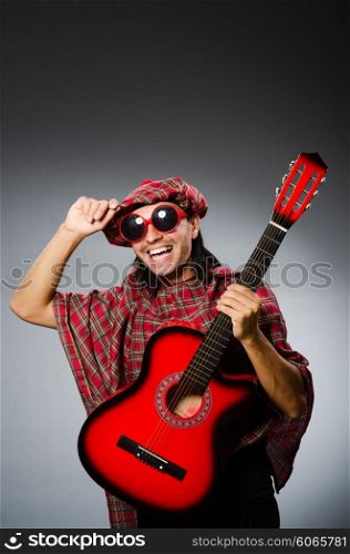 Funny scotsman playing red guitar