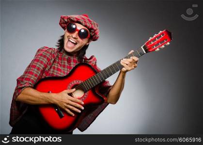 Funny scotsman playing red guitar