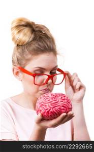 Funny silly weird woman in eyeglasses holding brain having something on mind, thinking of new concepts and ideas.. Funny silly woman holding human brain