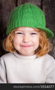 Funny smiling ginger kid in green hat
