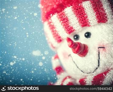 Funny snowman portrait against snowfall, abstract christmas backgrounds