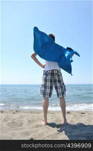 funny superhero standin at beach on hot sand