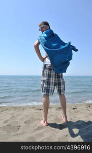 funny superhero standin at beach on hot sand